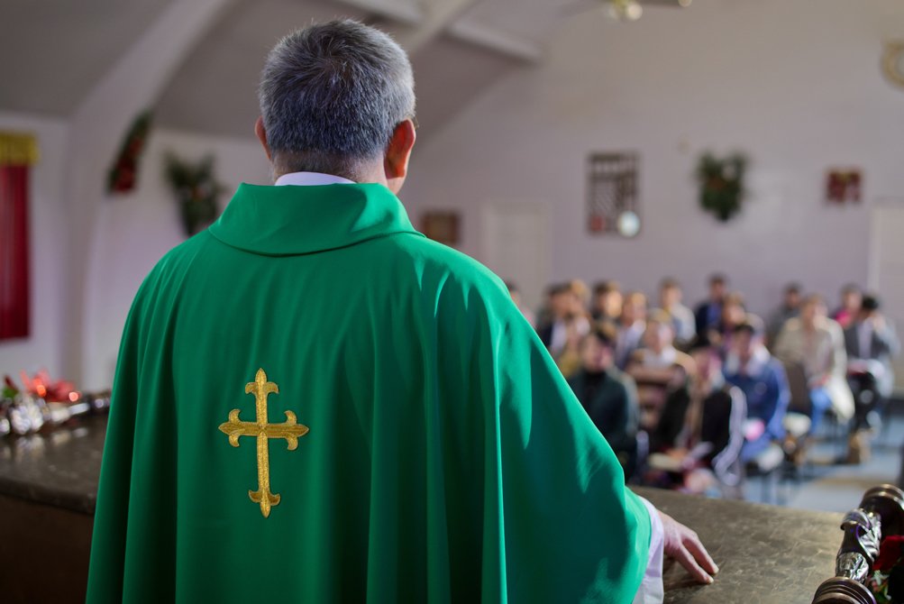 Sacerdote con casula verde durante una celebrazione